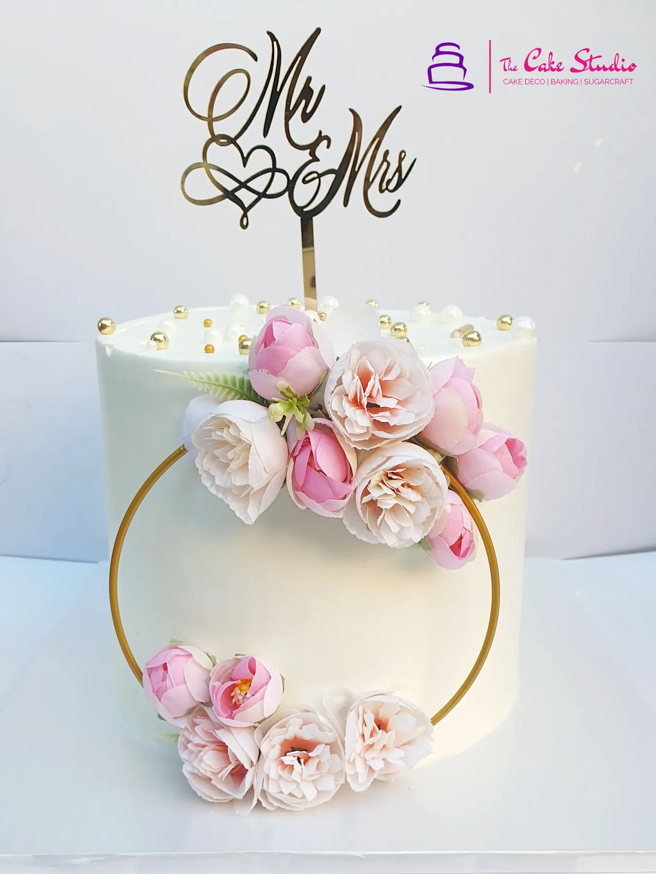 An elegant white anniversary cake with sugar peonies and a Mr & Mrs gold topper, by The Cake Studio Harare