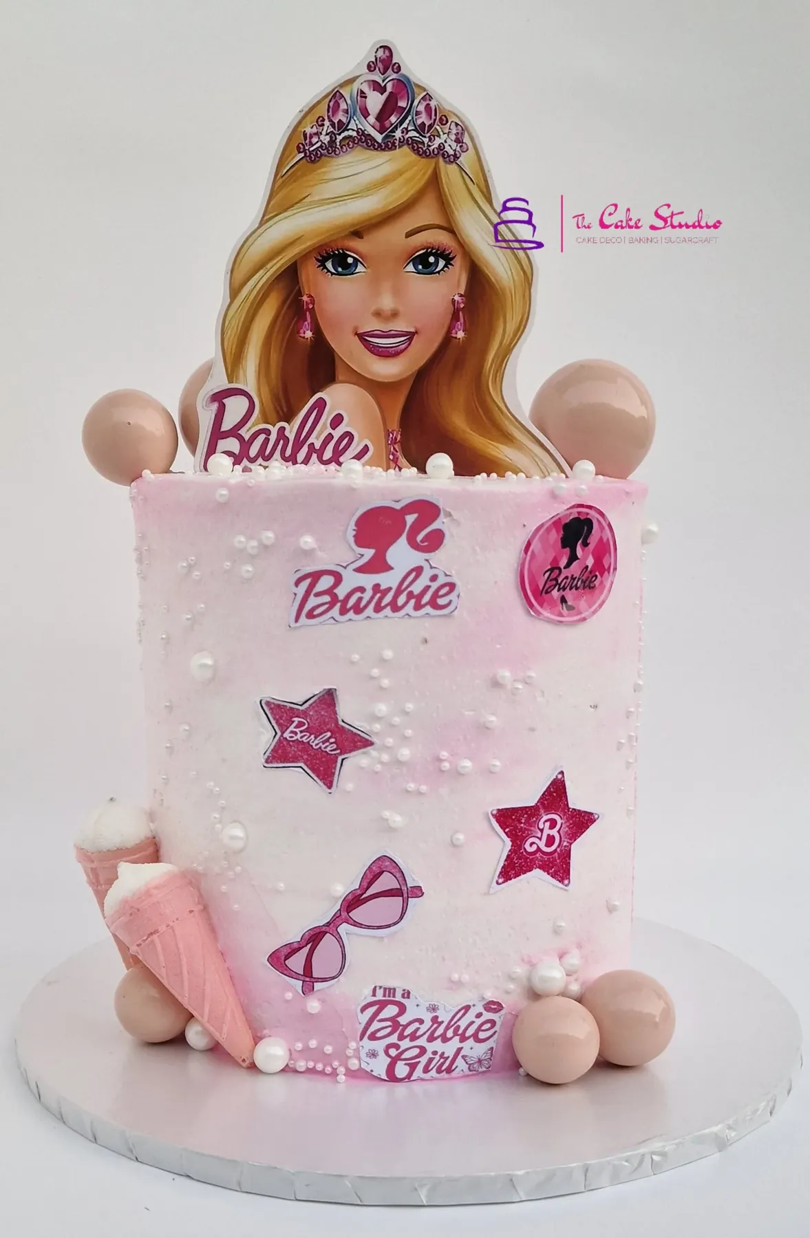 A Barbie character cake with tiara topper, pink finish and pearl detail, baked by The Cake Studio Harare