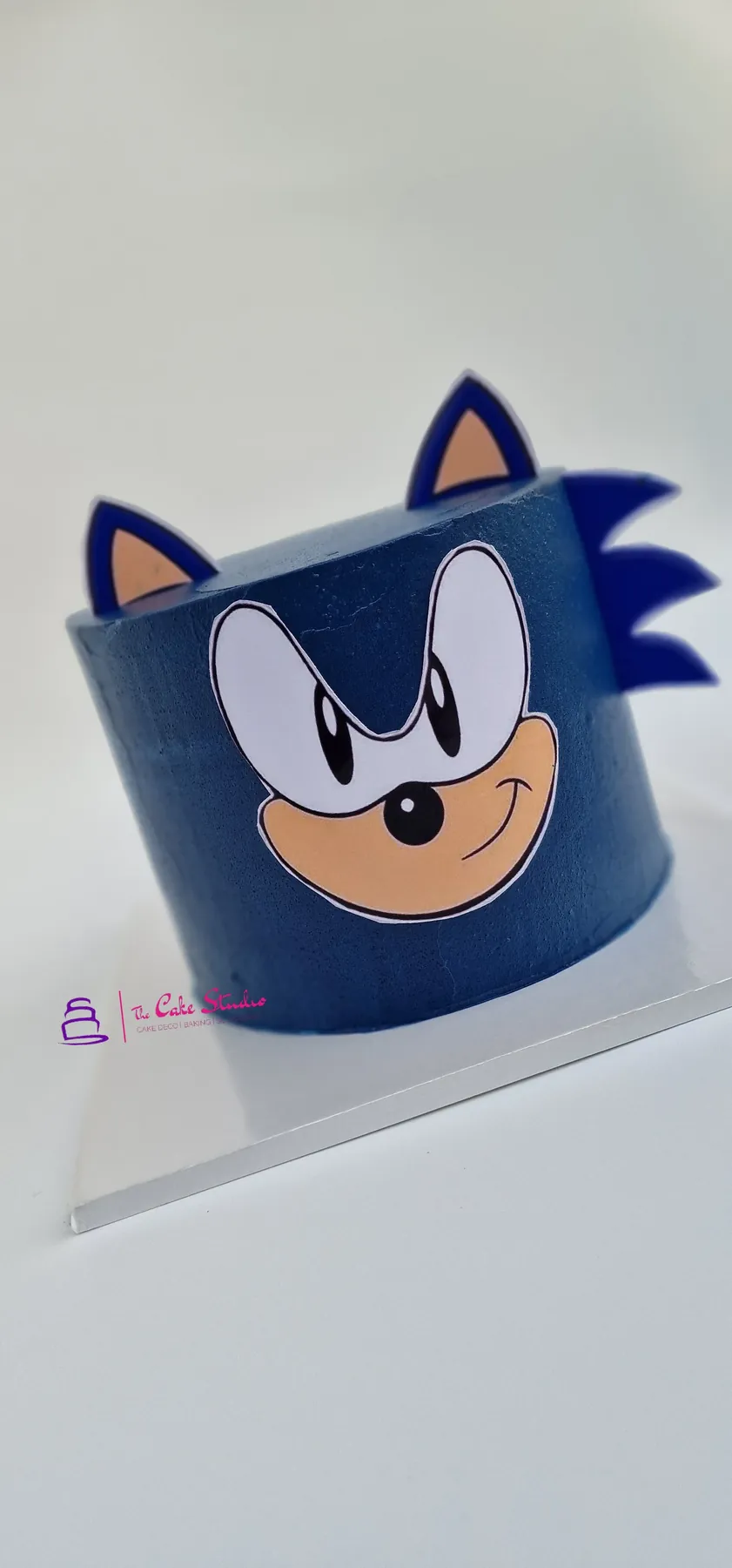 A Sonic the Hedgehog themed cake in deep blue with sculpted ears and quills, baked by The Cake Studio Harare