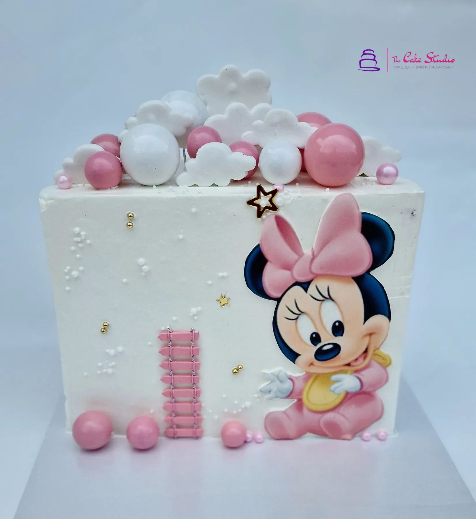 A baby Minnie Mouse character cake by The Cake Studio Harare with pink-and-white bauble clouds and pearl detail