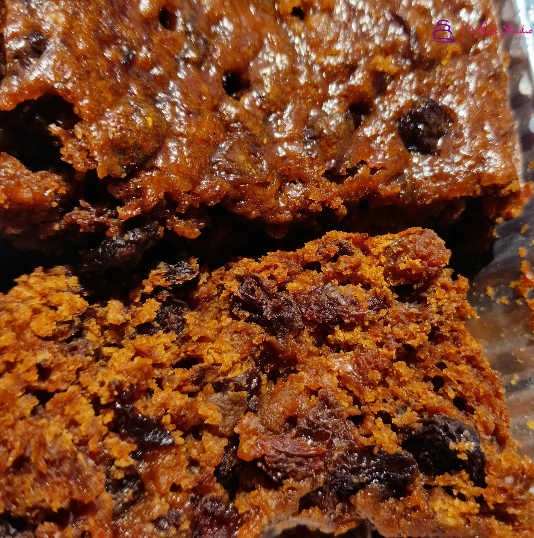 A close-up of rich fruit cake interior showing dense raisins, currants, and glace fruit, baked by The Cake Studio Harare