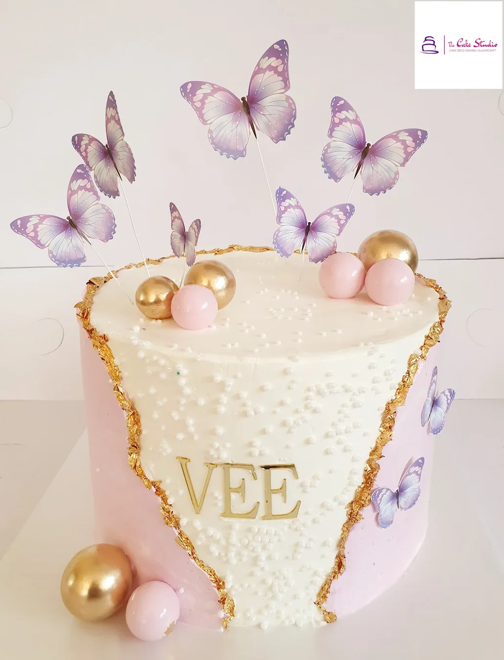 A white celebration cake with purple sugar butterflies