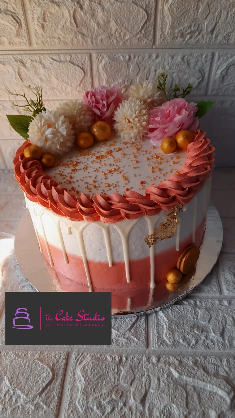 A blush drip cake with fresh fruit and roses