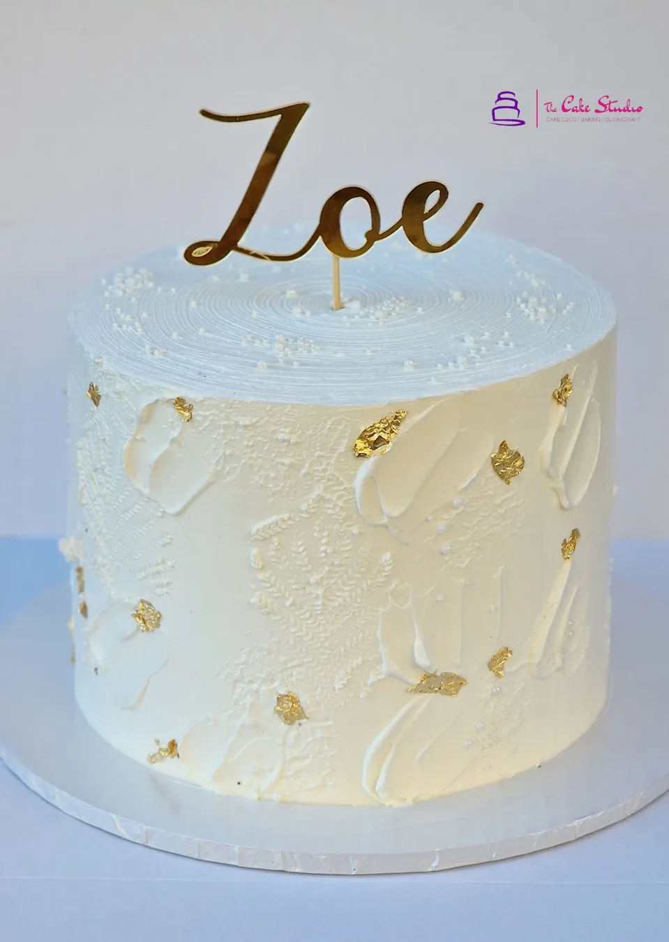 A white and gold drip celebration cake