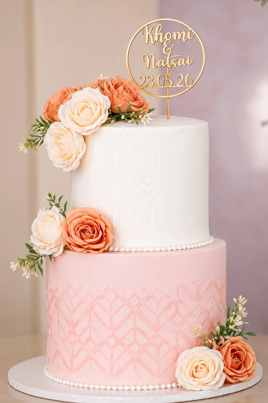 A two-tier wedding cake with a name topper