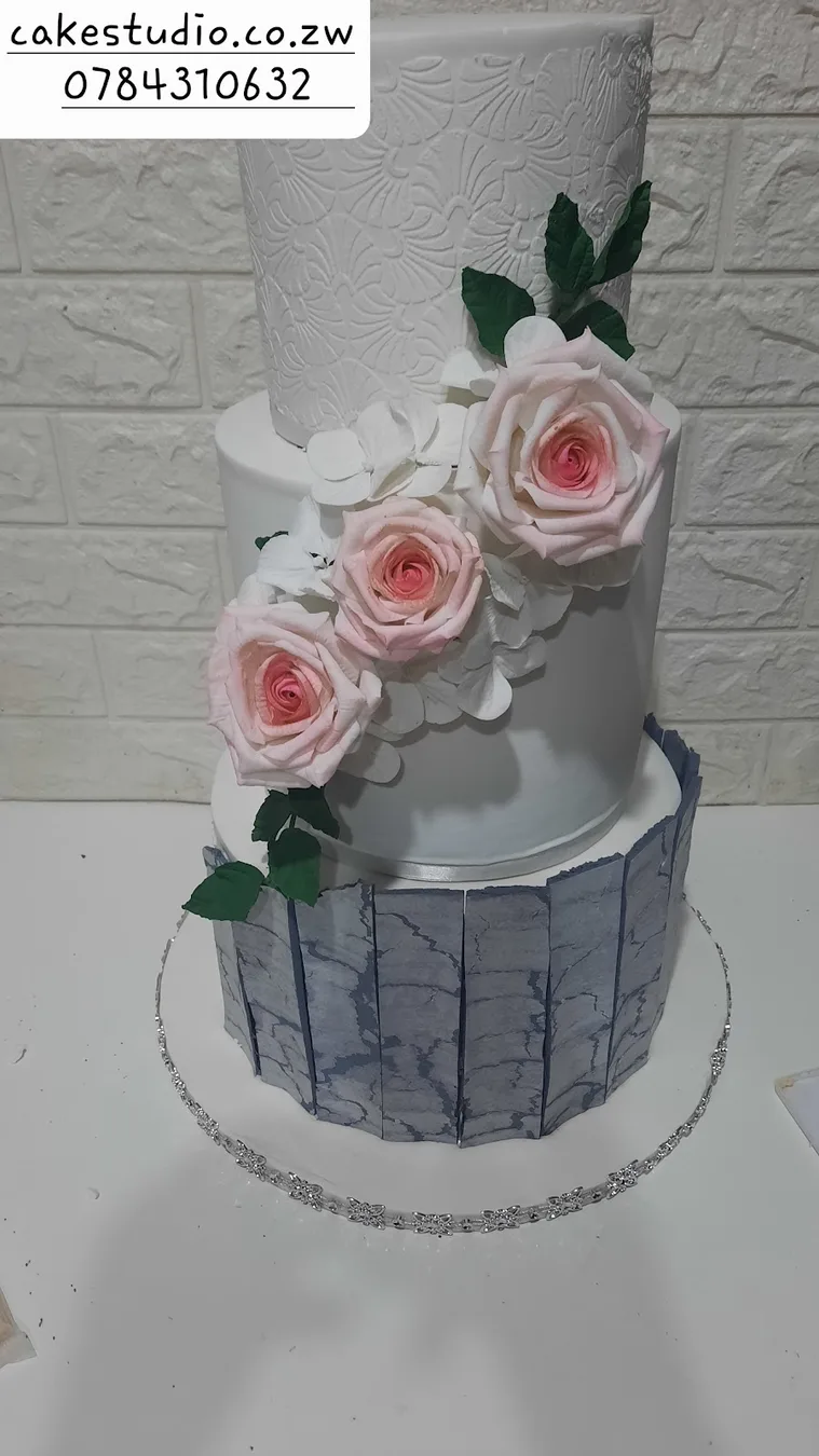 A silver and white two-tier cake with blush roses