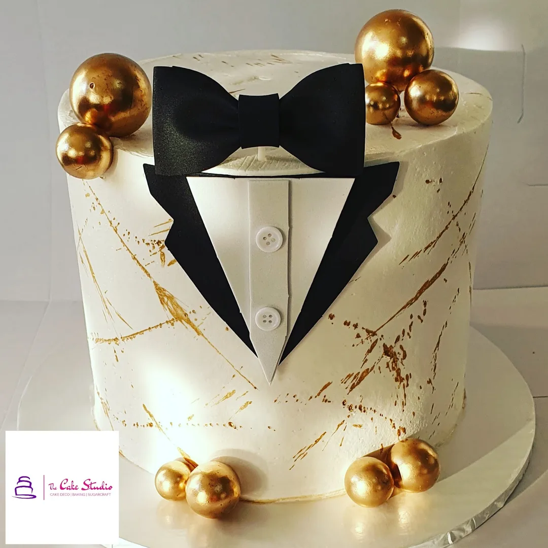 A white and gold tuxedo groom cake