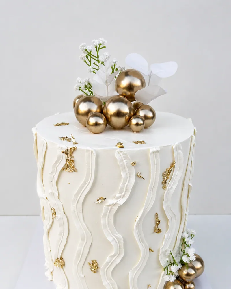 A Father’s Day cake reading xoxo Dad and kids in gold along the board, made by The Cake Studio Harare