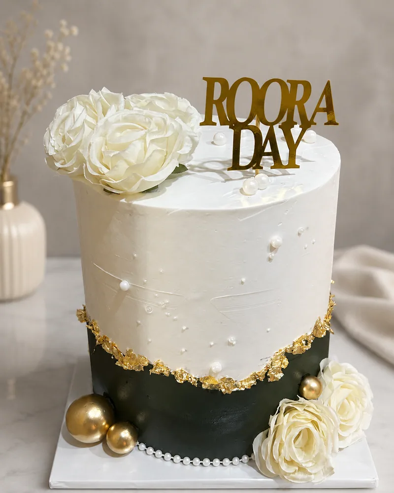 A Roora Day cake with a white top tier and a bold deep-coloured base, made by The Cake Studio Harare