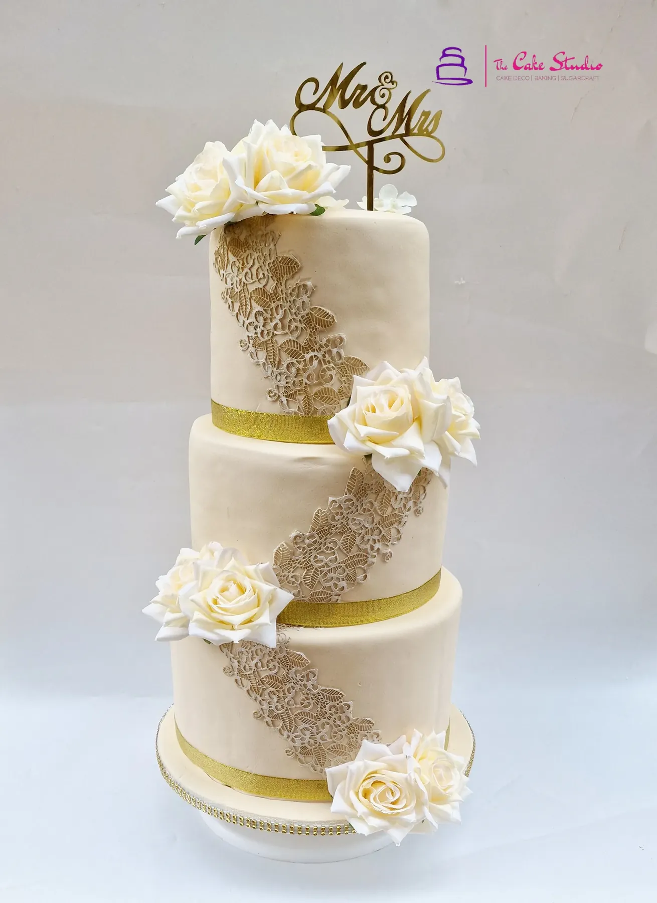 Hands piping buttercream onto a cake during a baking lesson