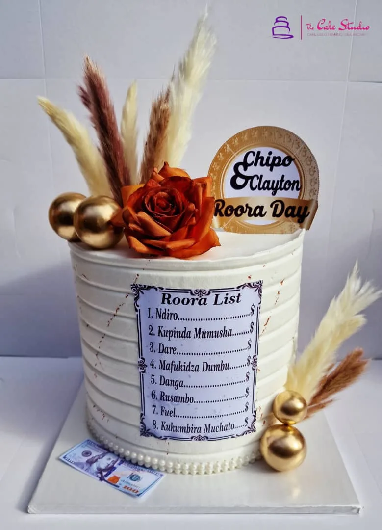 A Roora Day cake with a Roora List piped on the side and a Chipo & Clayton surname topper