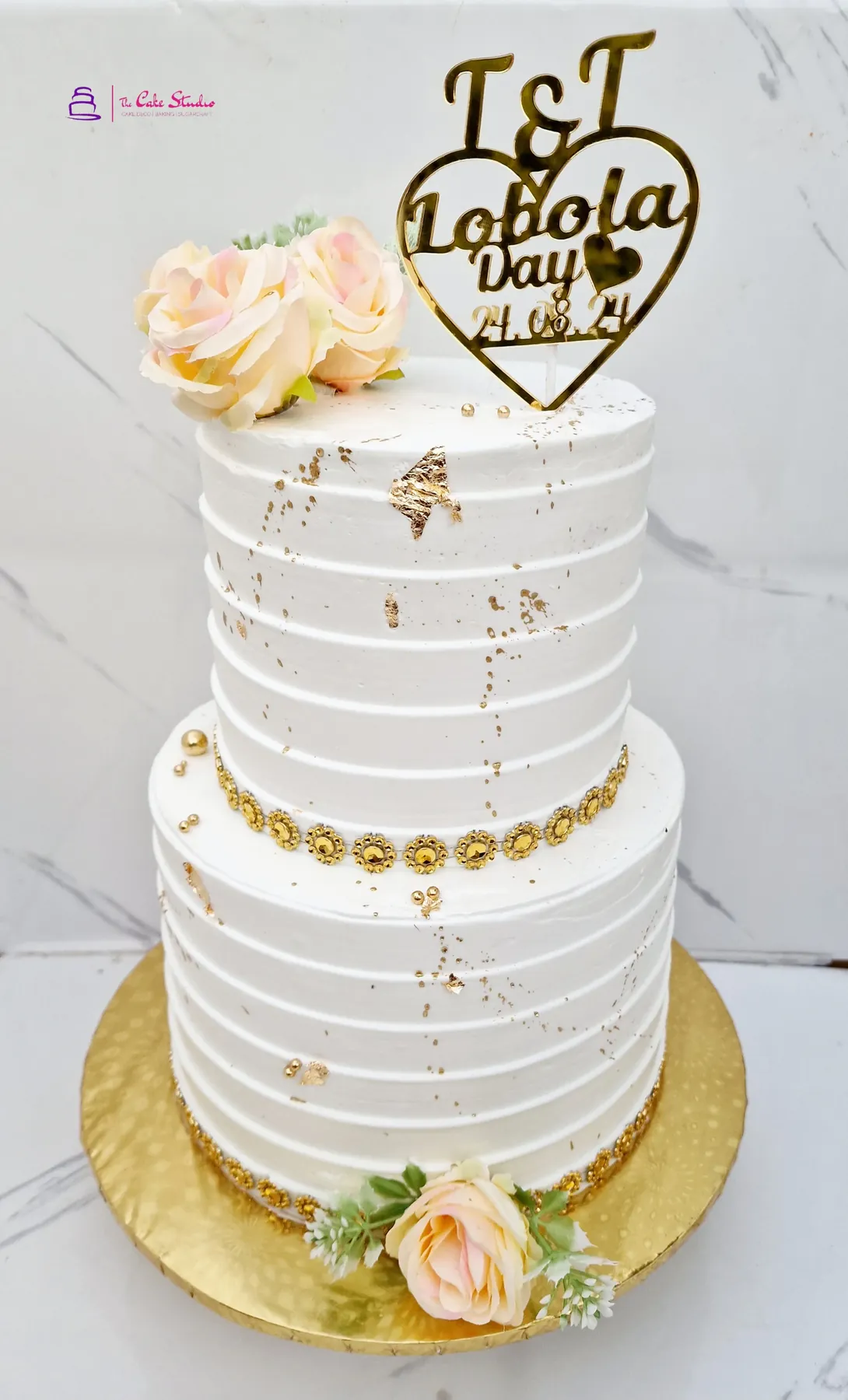 A two-tier Roora Day cake with sugar florals matched to the family colour palette