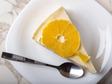 One slice of homemade orange cake on plate with teaspoon